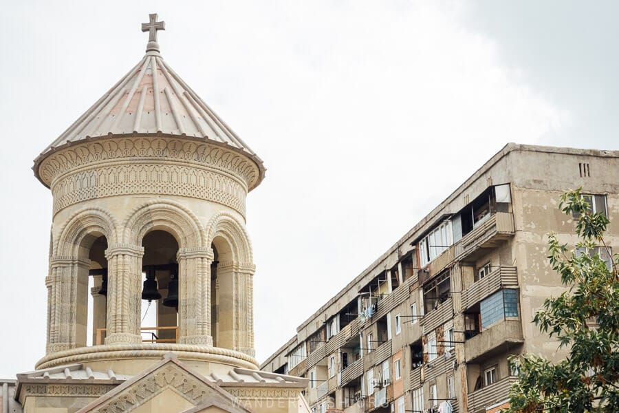 The belltower of the Rustavi Sioni church with apartment blocks in the background.