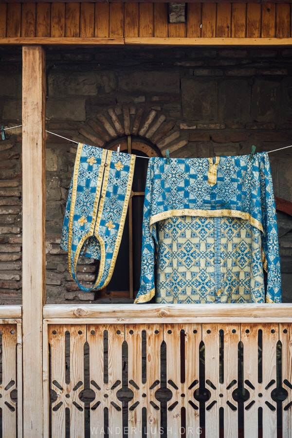 Church robes hanging from a wooden balcony in Rustavi.