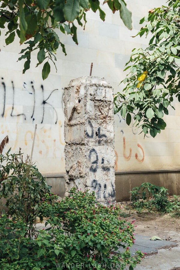 An empty plinth standing in front of the mosaic inside the Rustavi Metallurgy Plant.