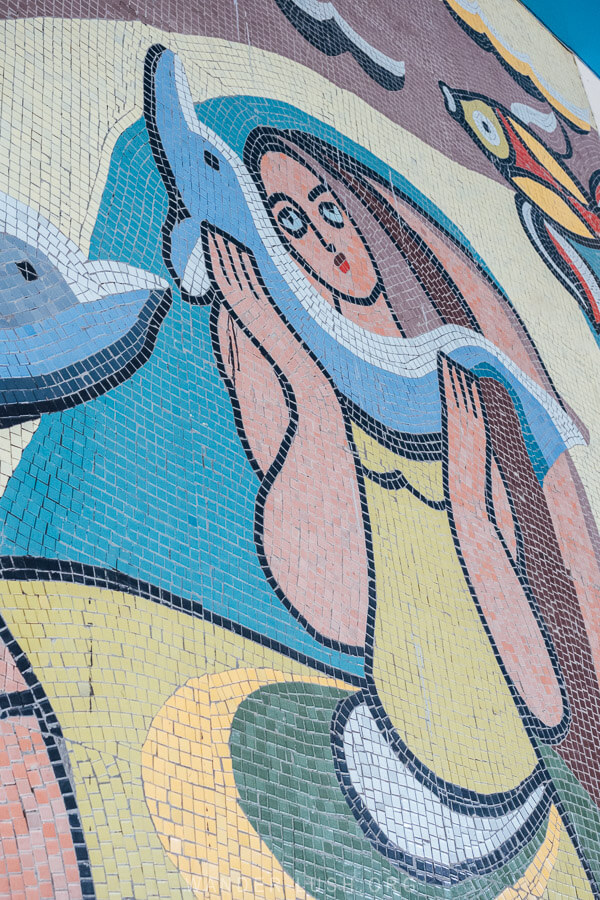 A Soviet era mosaic depicts a woman embracing a dolphin.