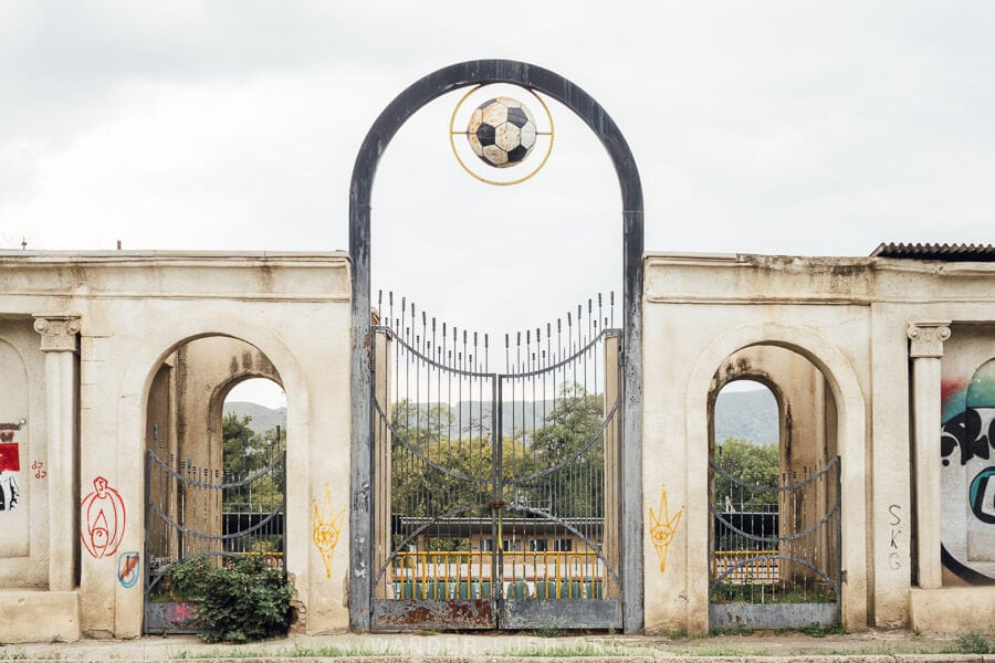 The entrance to Rustavi Stadium, with arches and a metal gate.