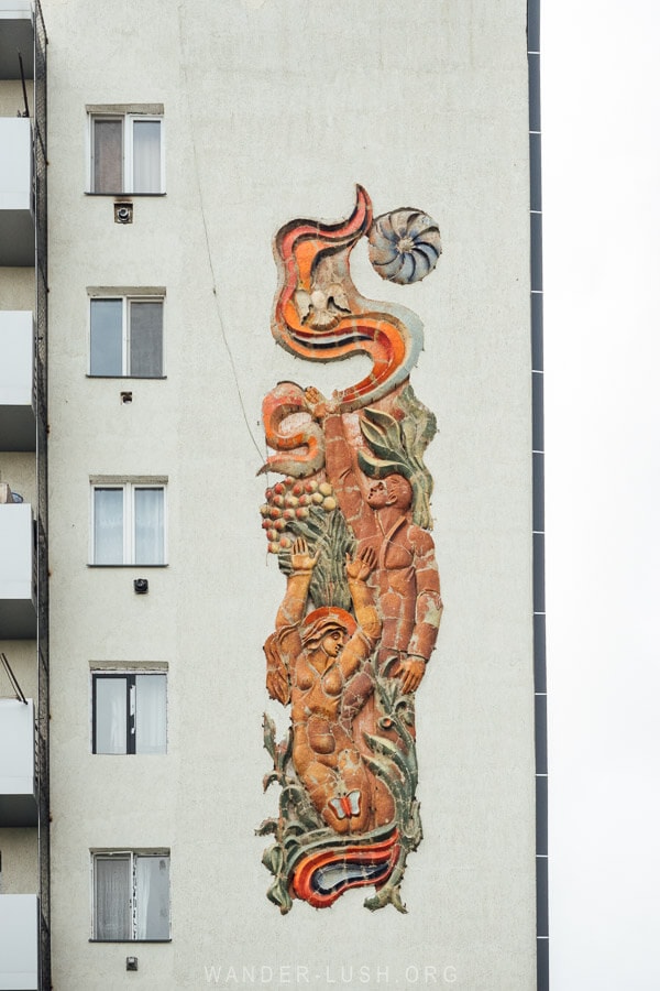 A Soviet era artwork on the front of an apartment block in Rustavi, Georgia depicting a man and a woman surrounded by flowers and butterflies.