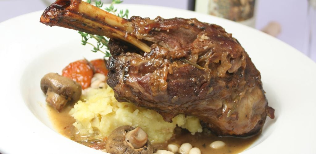 Braised lamb shank served over garlic mashed potatoes. 