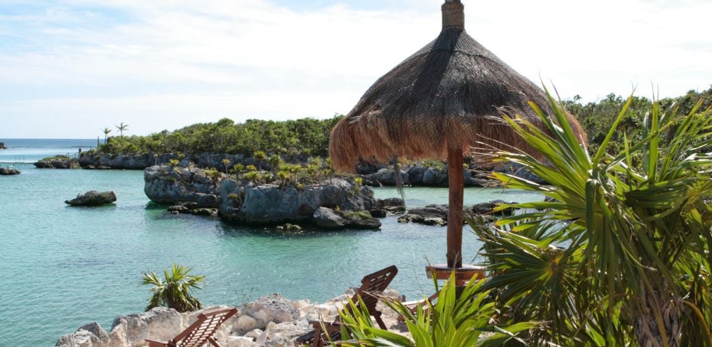 A beautiful lagoon, ocean, jungle, rocks, and beach hut. 