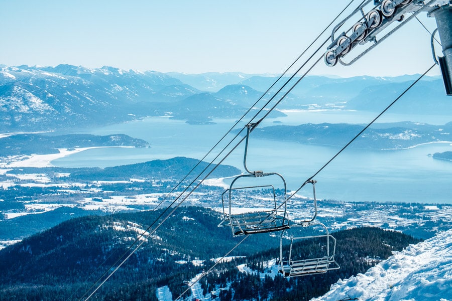 A chairlift runs past a beautiful lake in winter at the Schweitzer Ski Resort in Idaho.