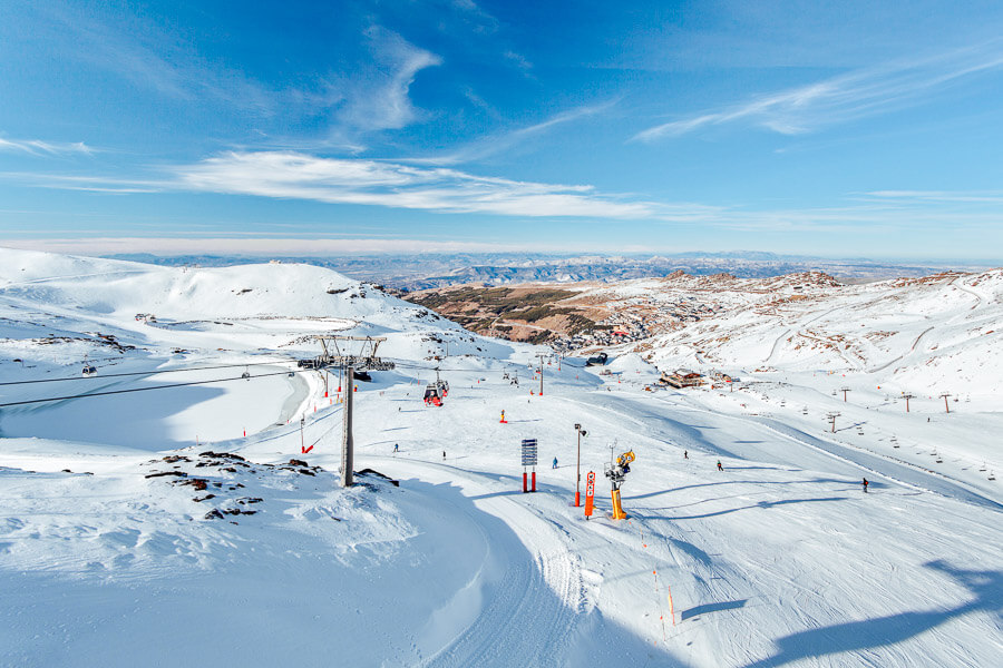 Ski runs in the Sierra Nevada in Spain, with mountains in the distance.