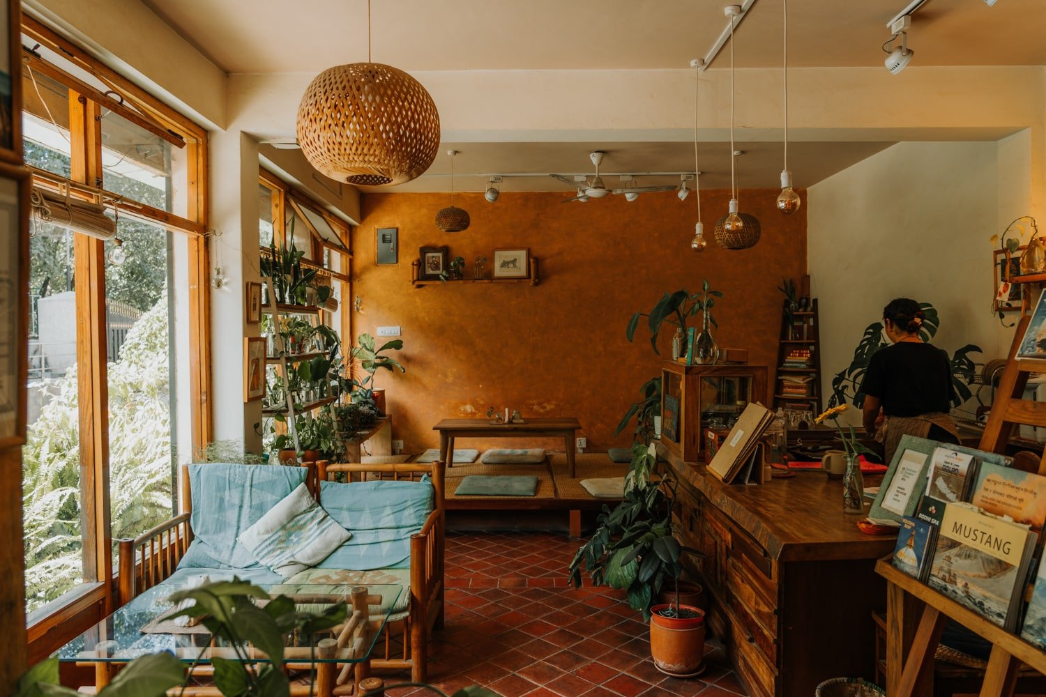 A plant and book-filled cafe in Kathmandu with earthy tones.