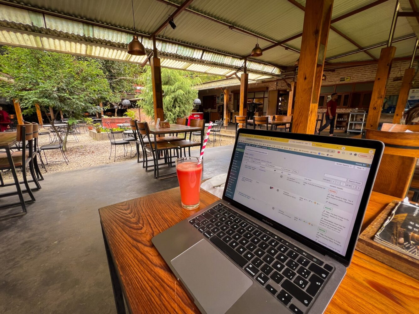 A Macbook laptop and juice sit on a table at the Uptala Cafe in Kathmandu.