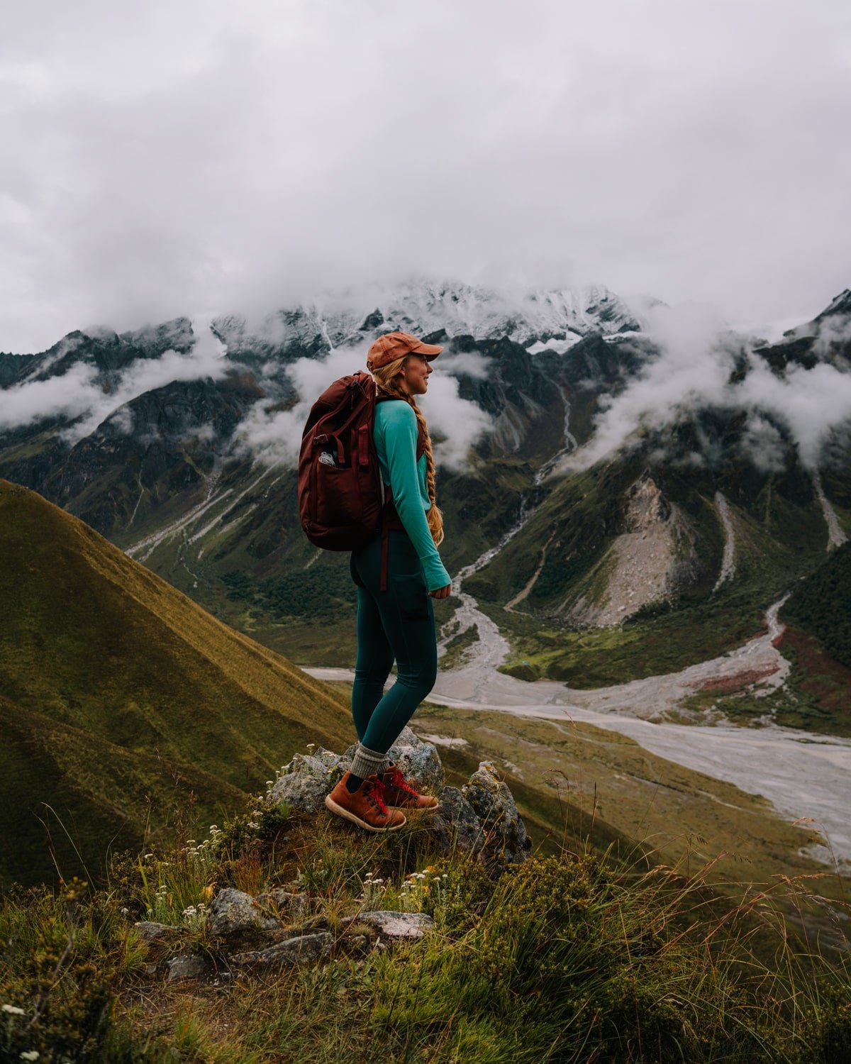 A female trekker stands overlooking glaciers and snow-capped peaks along the hiking trail in the Langtang Himalayas.