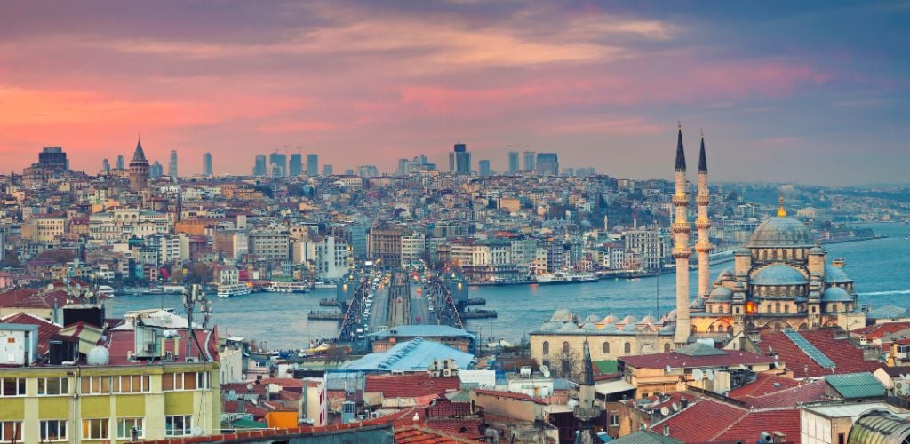 Panoramic image of Istanbul with yeni Cami Mosque and Galata Bridge during sunset. This is composite of two horizontal image images stitched together in photoshop. 