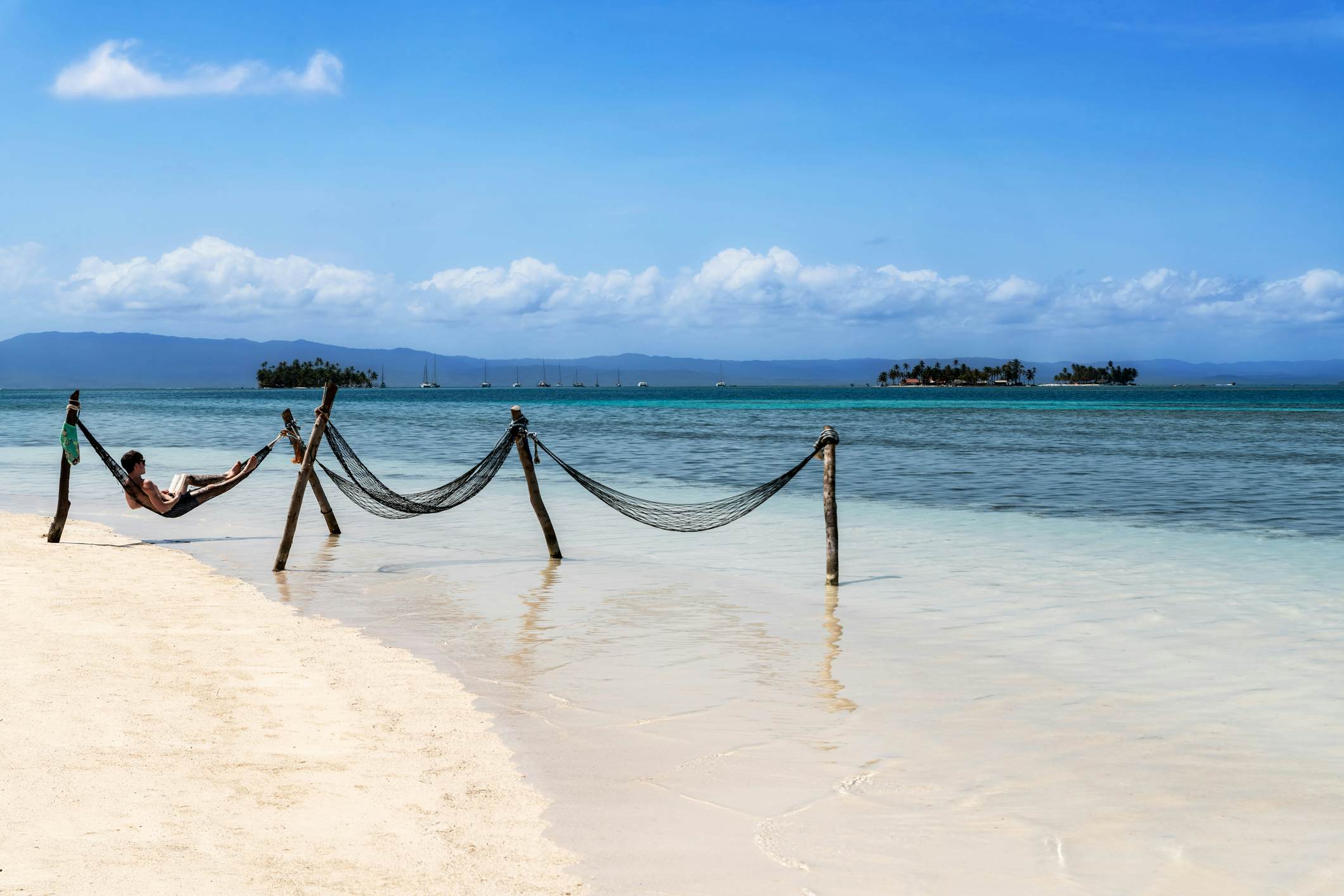 Tourist relaxing in the hammock on beautiful lonely beach in Caribbean San Blas island at politically autonomous Guna territory in Panama