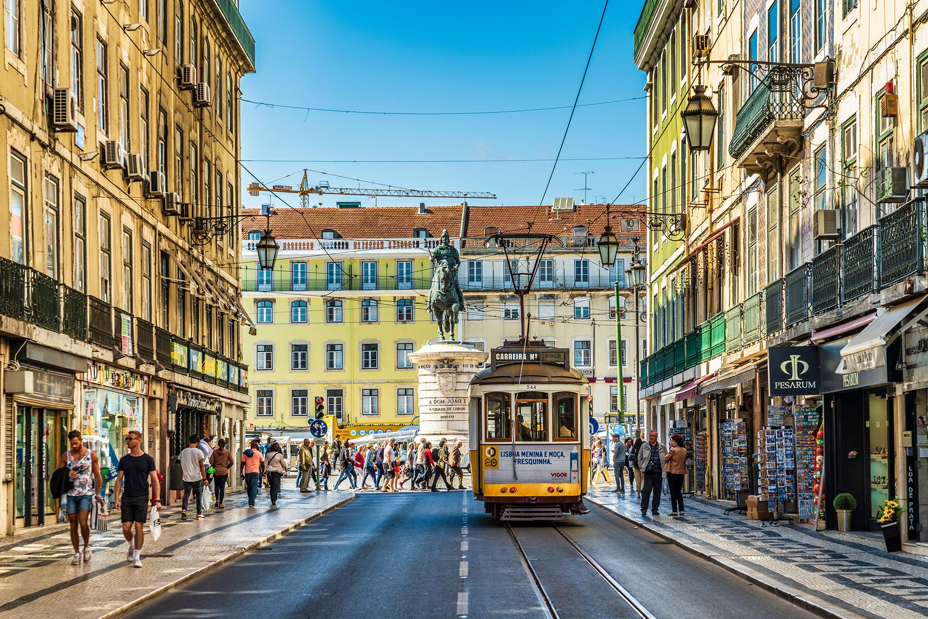 Typical street scene in Lisbon, Portugal containing people. Photo taken during a warm summer day.