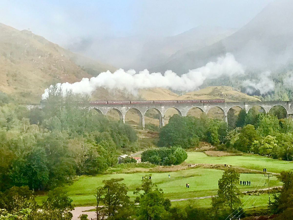 the Hogwarts Express gently chugging along Glenfinnan Viaduct, leaving a veil of smoke