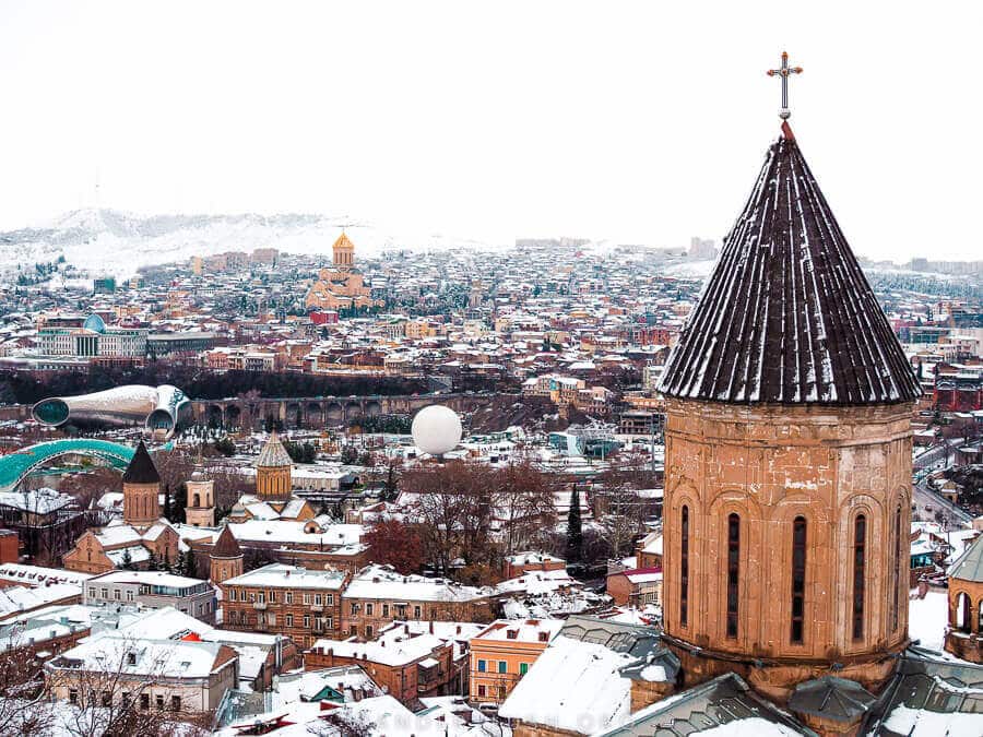 Tbilisi in winter, with snow on the mountains.