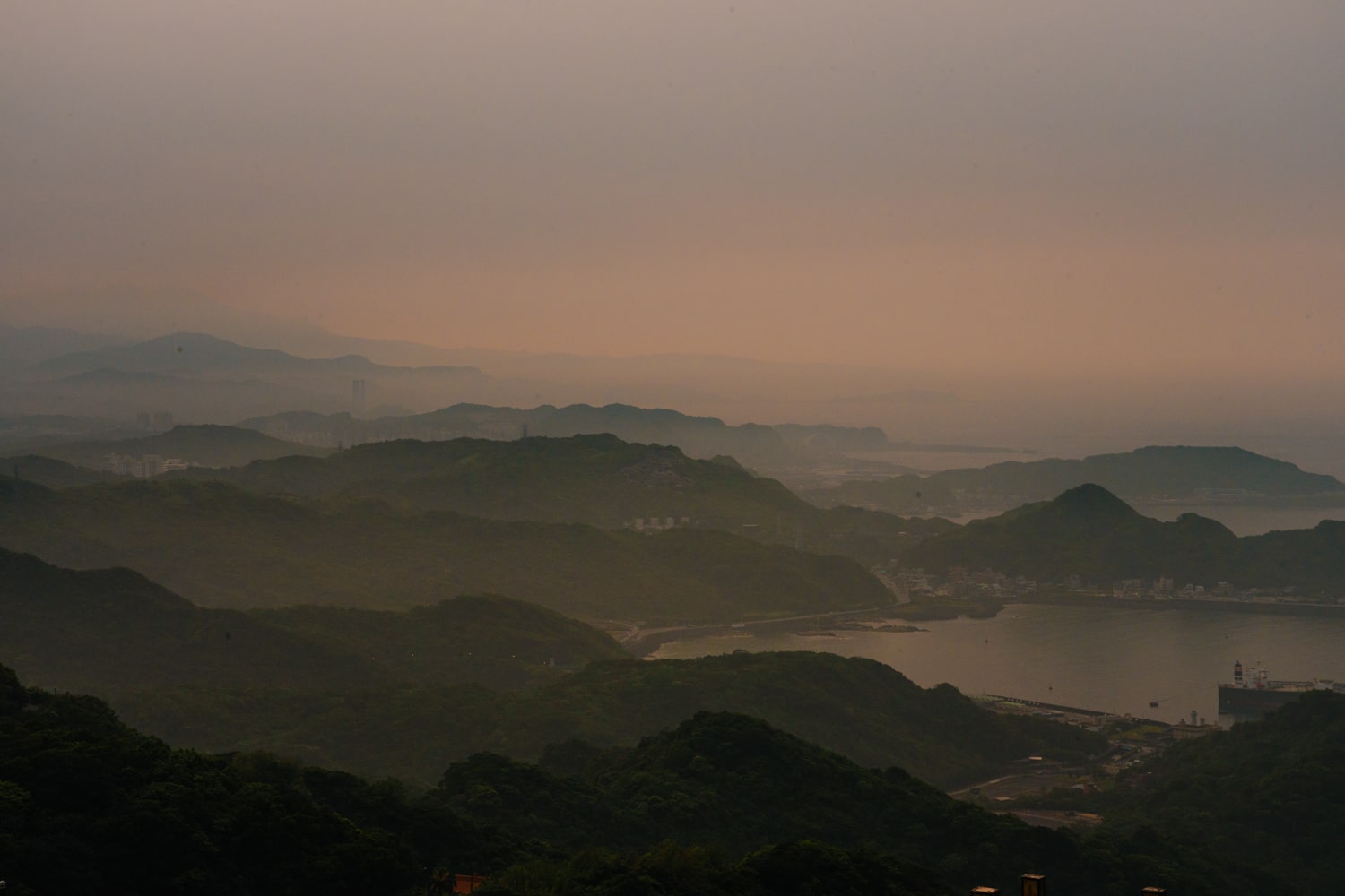 Hazy sunset with layered mountains overlooking Keelung Bay in Northern Taiwan.