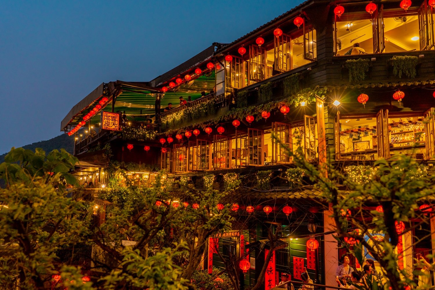 The "Spirited Away" inspired Amei Teahouse in Jiufen, Taiwan, at night illuminated with red lanterns and fairy lights.