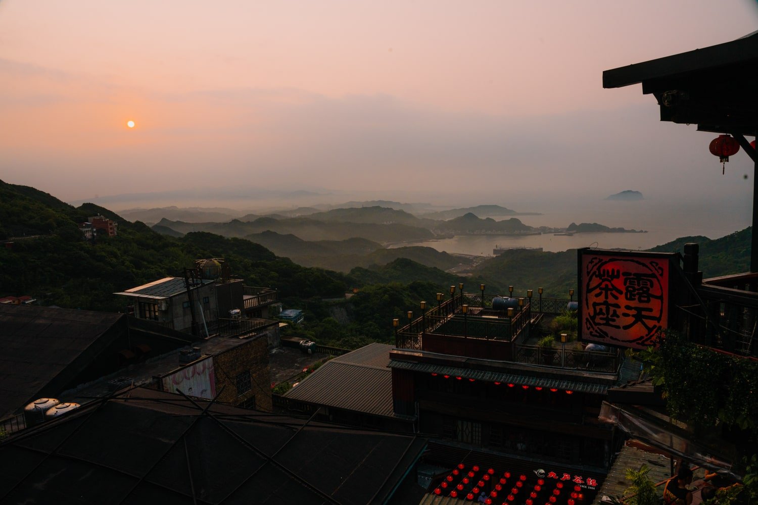 Sunset over hazy mountains and Keelung Bay, view from teahouse in Jiufen, Taiwan.