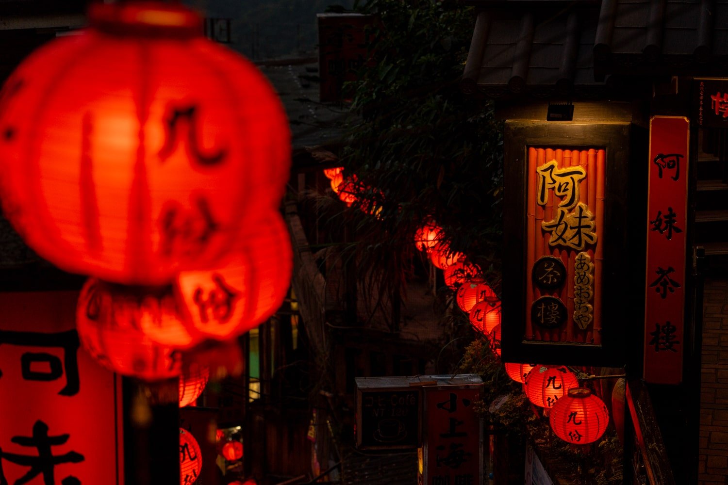 Red lanterns illuminate Jiufen Old Street at night.