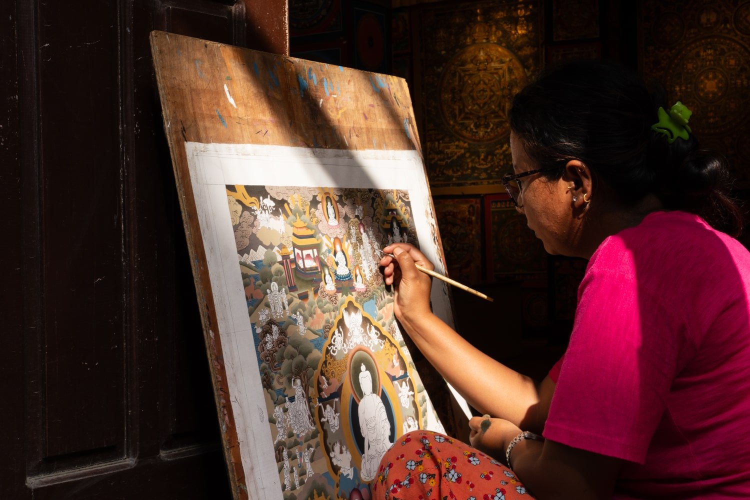 A local Nepali woman is painting Thankpa Tibetan mandala art at a school in Patan Durbar Square.