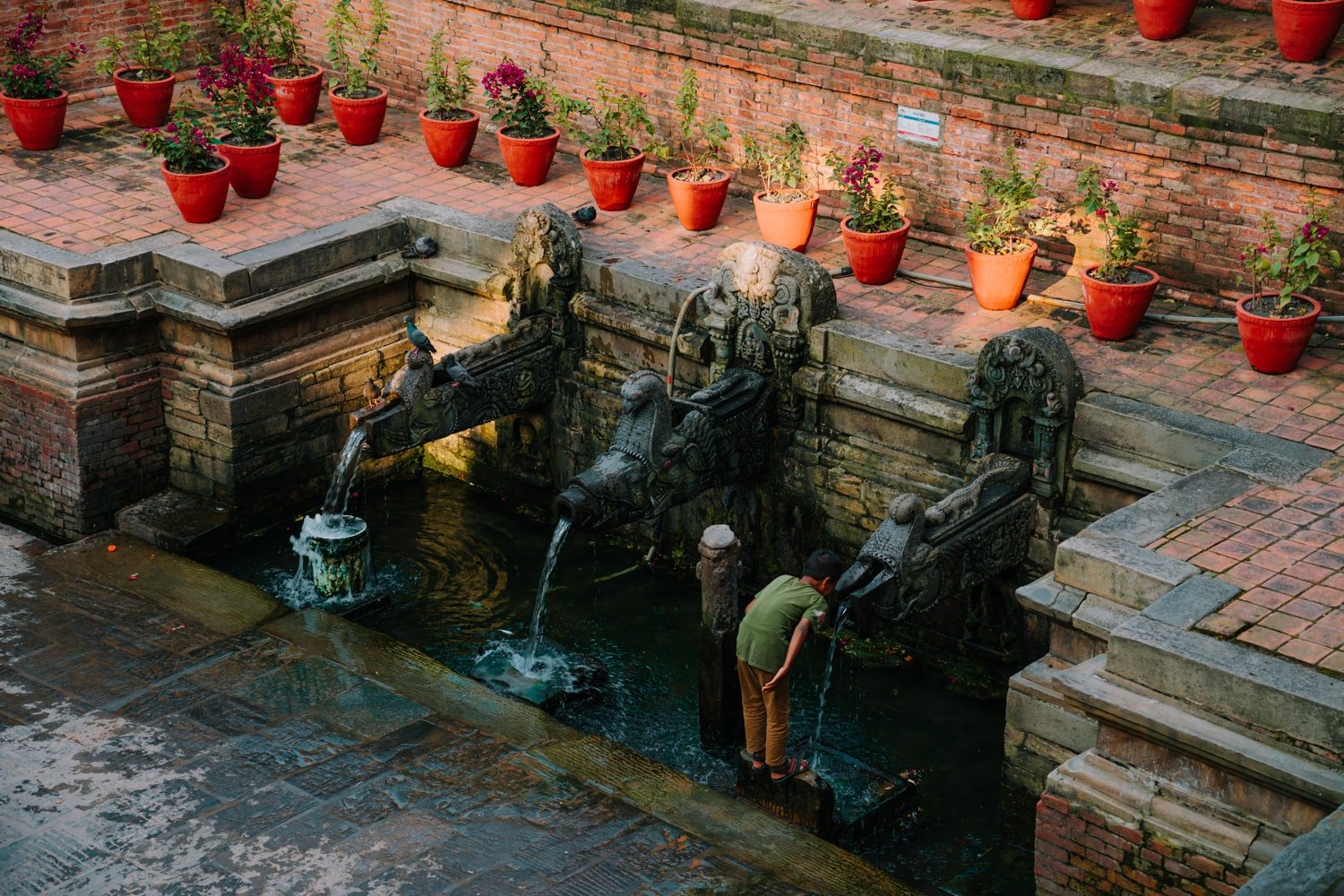 Nepali boy at ancient fountain in Patan.