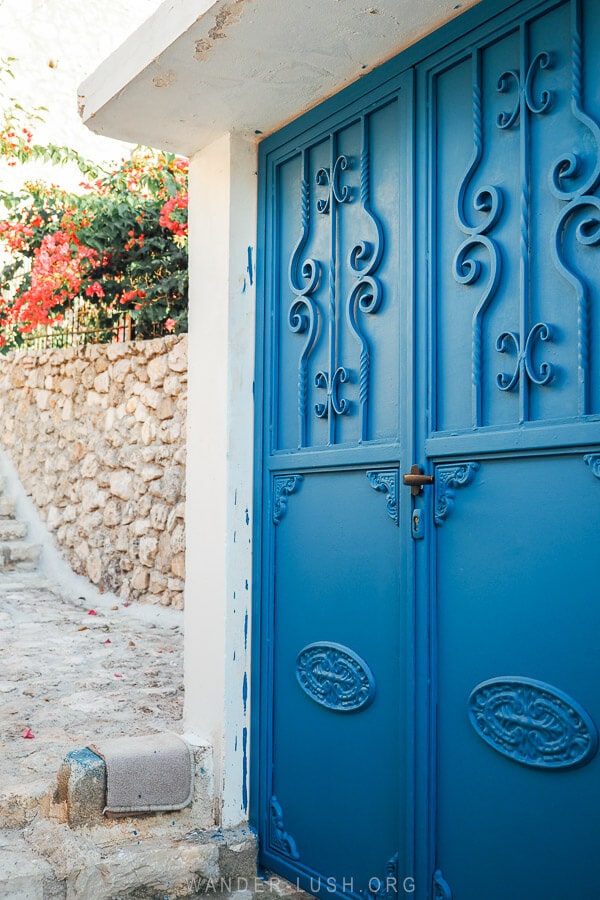 A blue gate on a cobbled street in Dhermi.