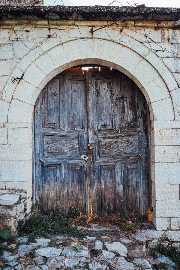 An old wooden door on a stone house in Vuno village in Albania.