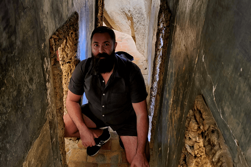 Kneeling in the hallway of the dormitory with all the little cork lined doors.