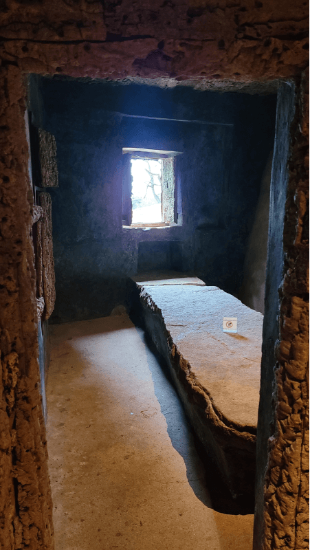 The rectory/dining room at the Convent of the Capuchos with large stone table in the center of the room