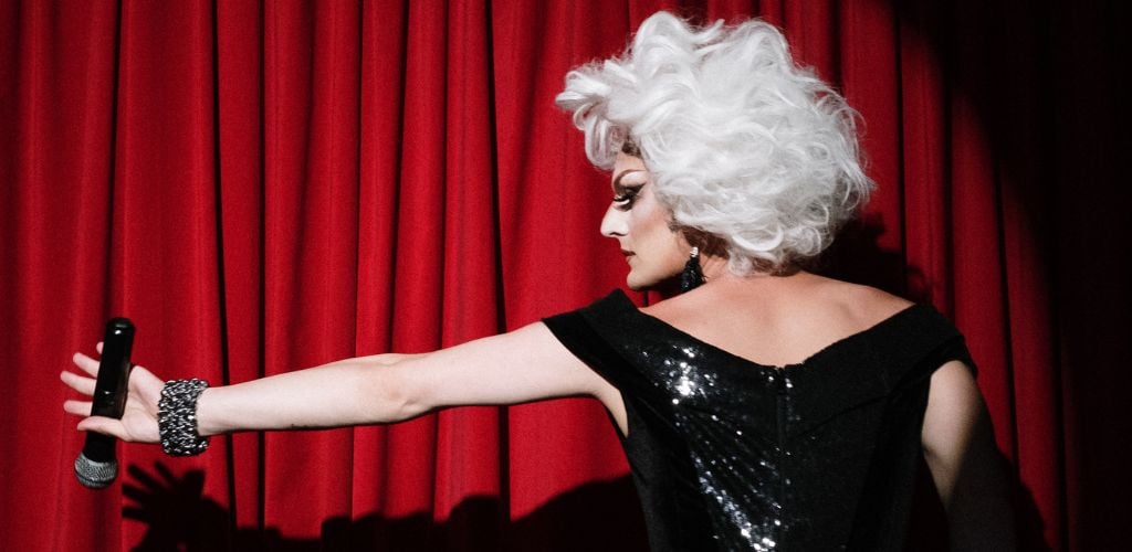 Drag Queen Holding a Microphone on Stage