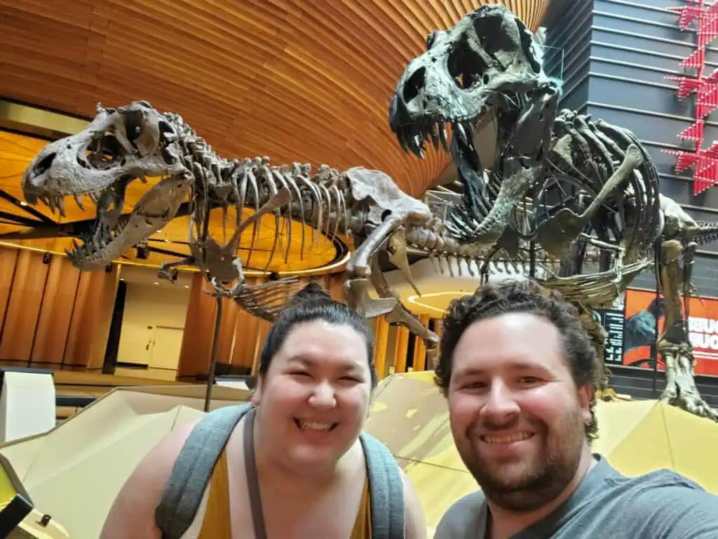 Colin and Riana posing with dinosaurs at the Auckland War Memorial Museum