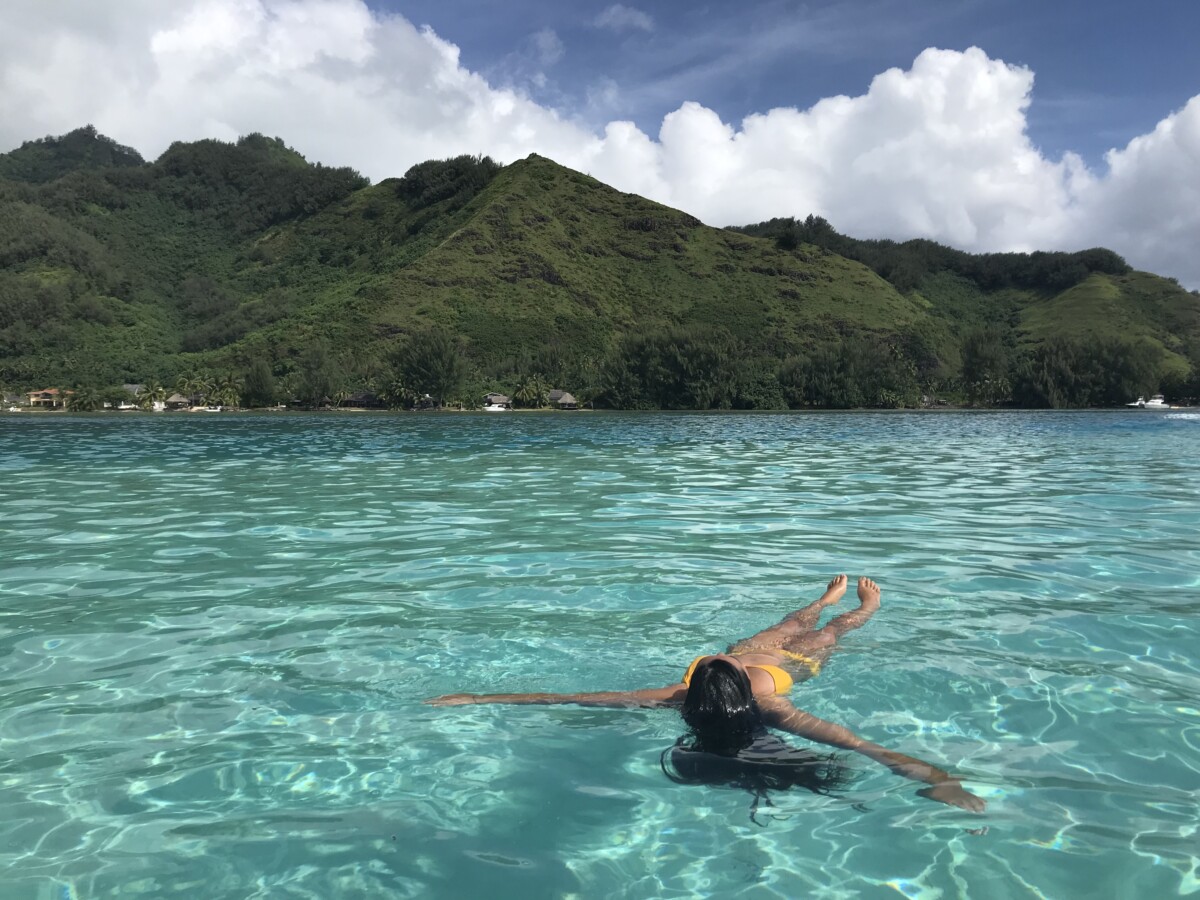 Woman floating in Moorea's lagoon in French Polynesia