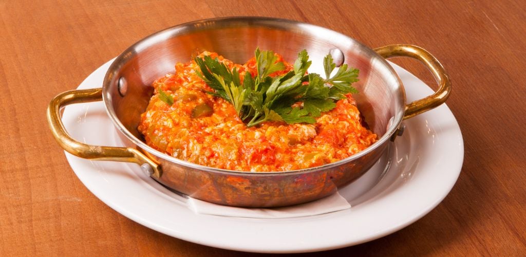 Scrambled eggs with tomato on a wooden table. 