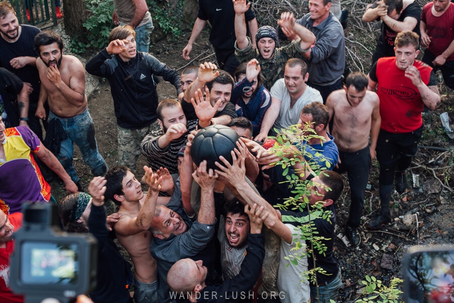 A man holds a ball overhead at Lelo Burti 2022 in Guria, Georgia.