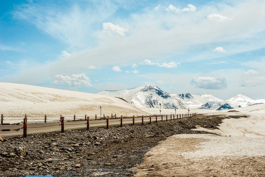 The Georgian Military Highway, a main road in Georgia stretching from Tbilisi to the Russian border, against a backdrop of snowy mountains in winter.