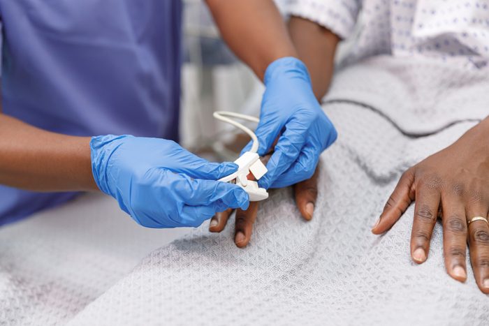 Nurse using pulse oximeter on hospitalized patient