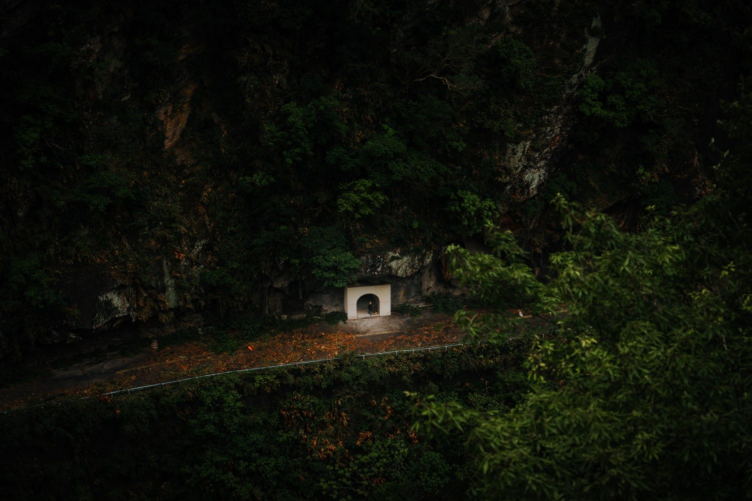 Moody photo of man entering into tunnel on road inside Taroko National Park, Taiwan.