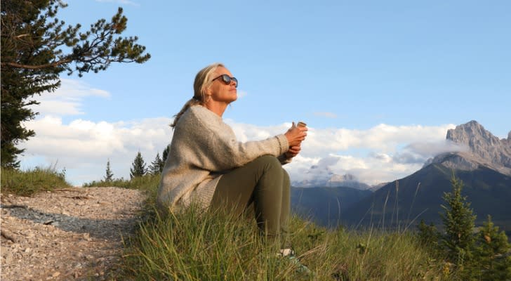 An woman who retired early enjoys the view during a hike.