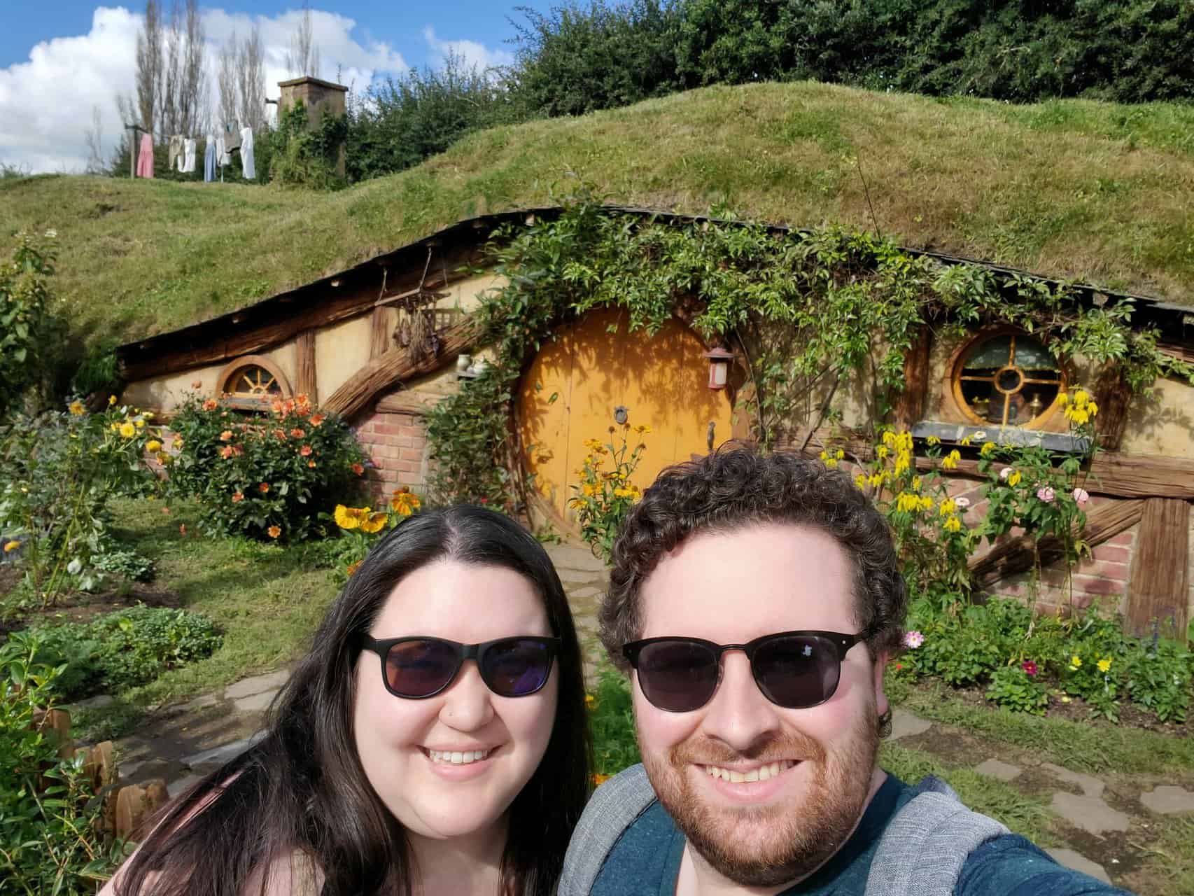 Colin and Riana selfie in front of a yellow door at Hobbiton in New Zealand