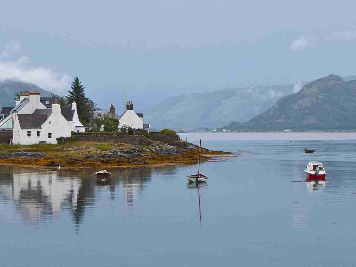 whitewashed stone cottages on a misty by Loch Carron; view of Loch Carron from Plockton © timelesstravelsteps.com