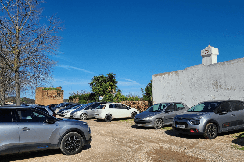 Cars in a gravel parking lot in Silves Portugal in the Algarve.