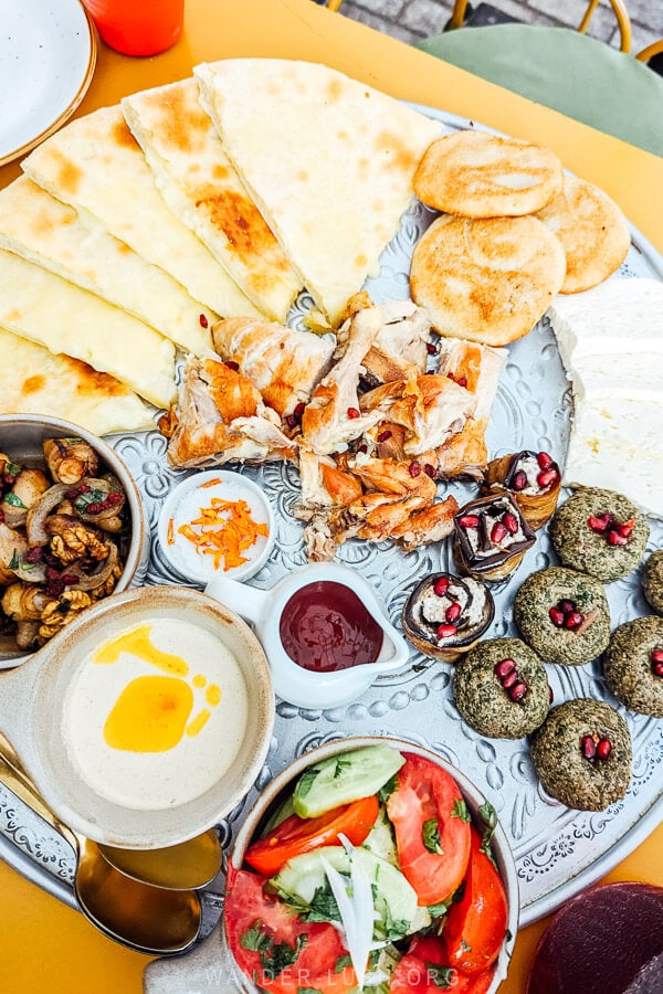 A wooden board heaped with Georgian food at a restaurant in Kutaisi.