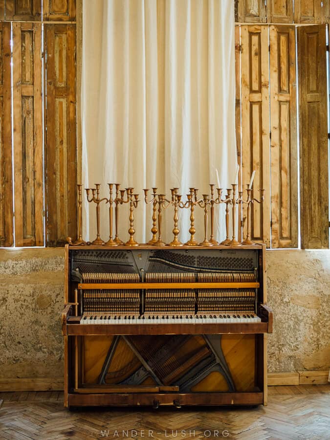 A piano displayed against a backdrop of sheer curtains.