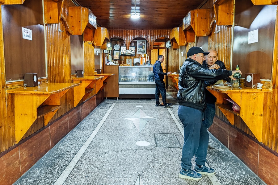 Two men eating Georgian kebab at Bikentia's, a classic retro restaurant in Kutaisi, Georgia.