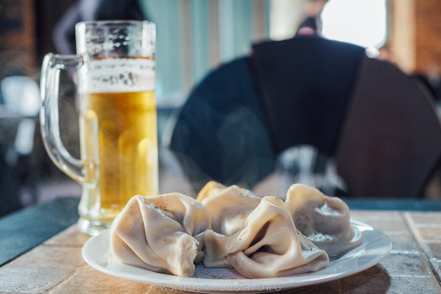 A plate of steaming khinkali dumplings on a restaurant table, El Depot, serving the best khinkali in Kutaisi.