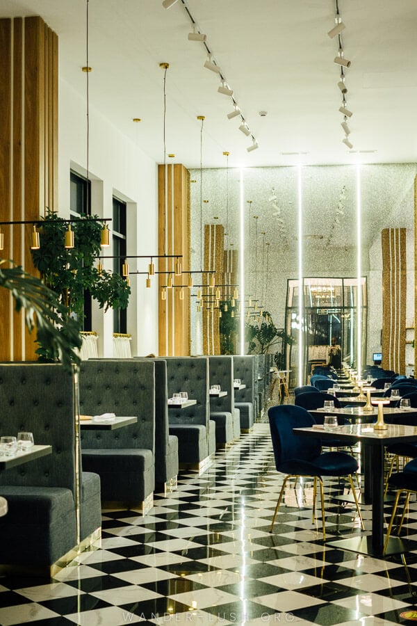 The trendy interior of Cafe Newport in Kutaisi, with black and white tiles and Deco lights.