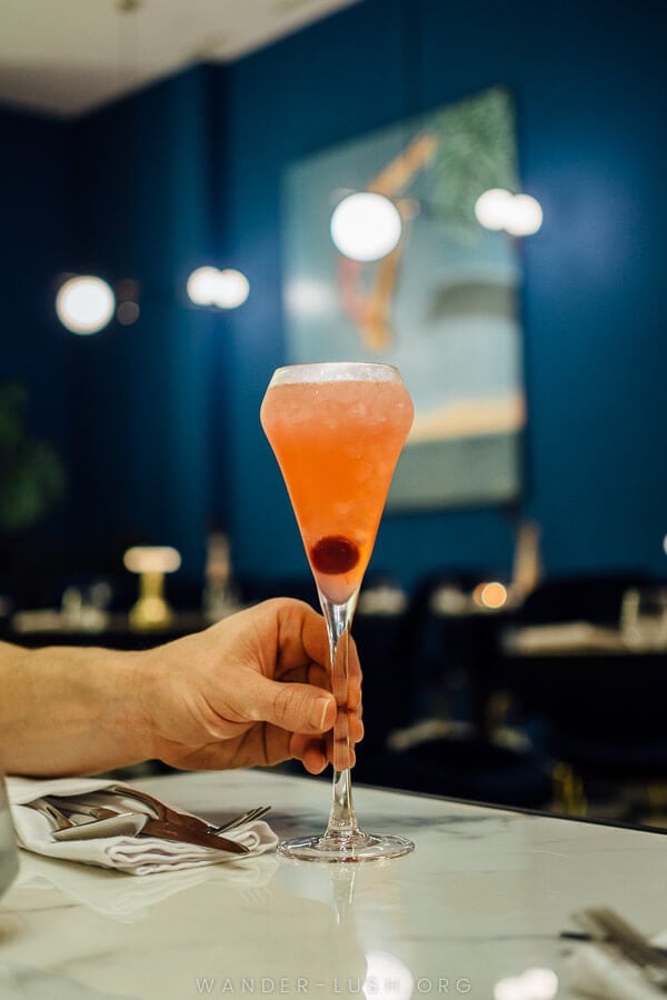 A person holds a pink cocktail at a bar in Kutaisi, Georgia.