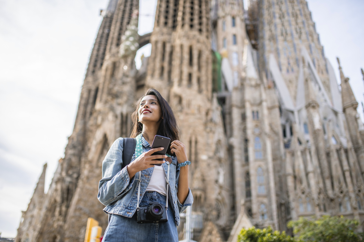 A woman standing in front of the Sagrada Familia cathedral