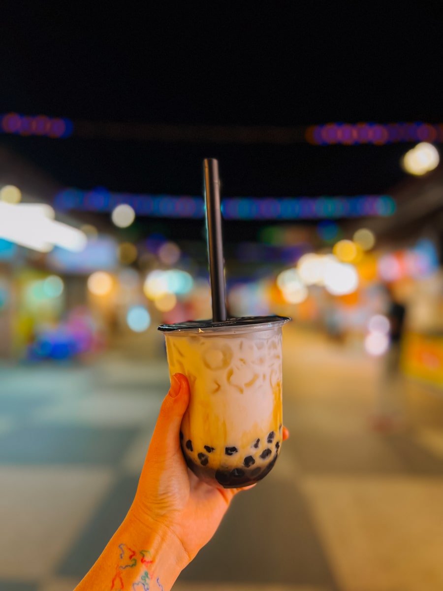 Woman holding up Pearl Bubble Tea at Dongdamen Night Market in Hualien, Taiwan.