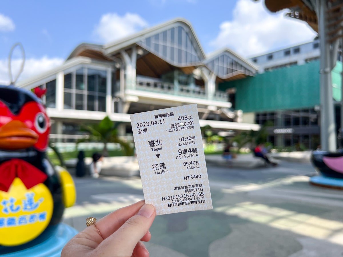 Holding train ticket stub in front of Hualien Train Station, Taiwan.