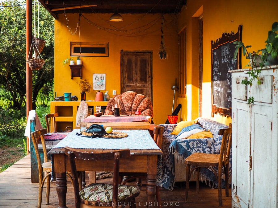 Tables and chairs on a brightly lit verandah at Karma Hostel in Martvili, Georgia.